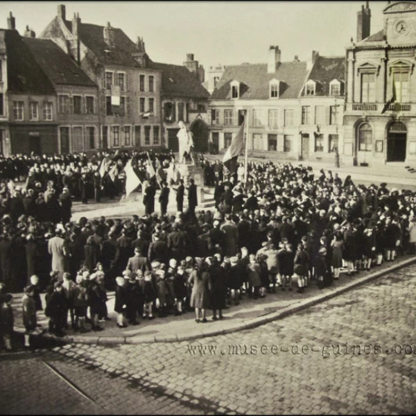 manifestation patriotique devant le monument aux morts abîmé, dans les années d'après-guerre, avant la restauration